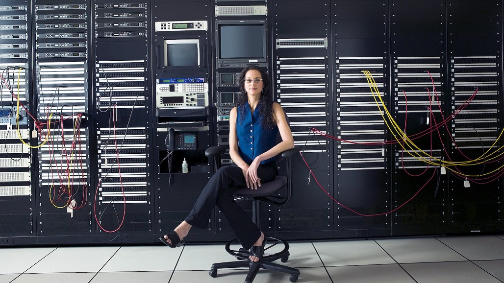 Young businesswoman sitting by computer control panel